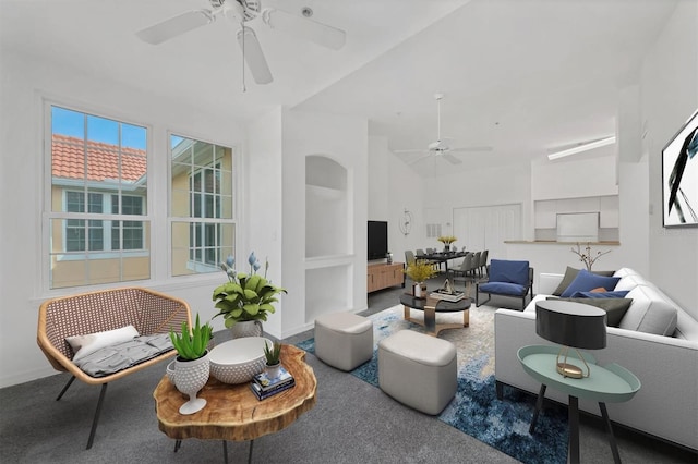 living room featuring baseboards, plenty of natural light, and ceiling fan