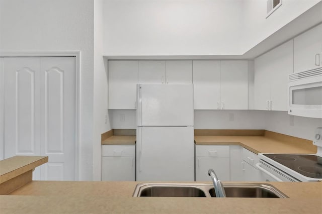 kitchen featuring a sink, white appliances, white cabinets, and light countertops