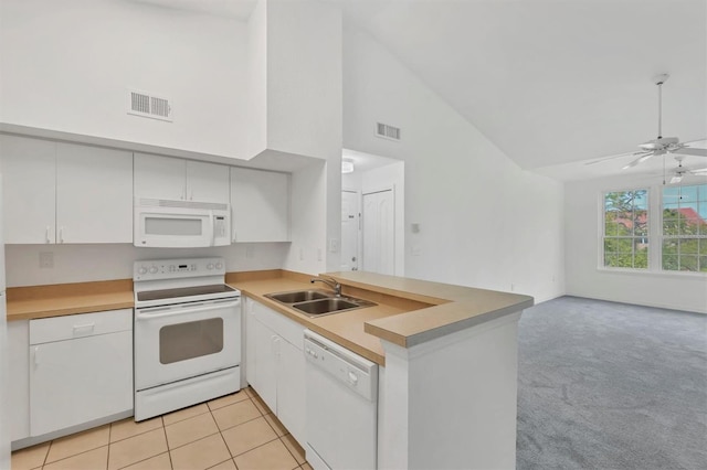 kitchen featuring a sink, visible vents, white appliances, and a peninsula