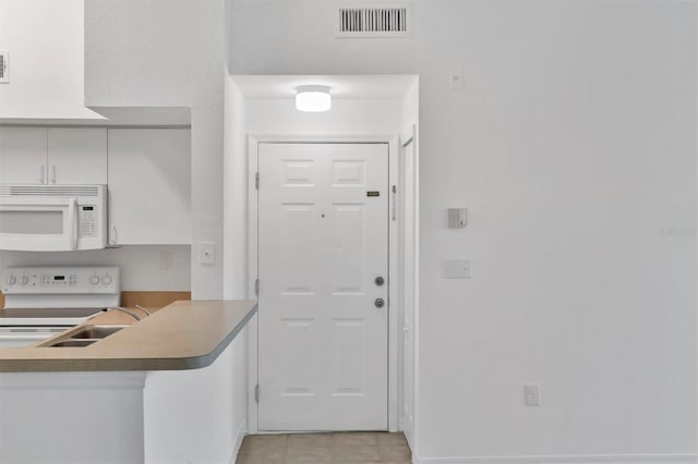 kitchen featuring a sink, visible vents, and white appliances