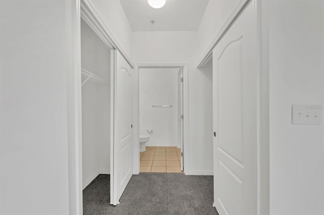 hall featuring dark tile patterned floors and dark carpet