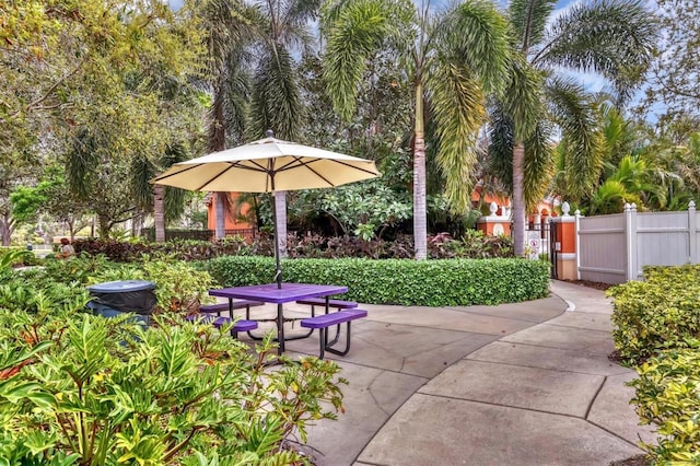 view of home's community with a patio area, outdoor dining area, and fence