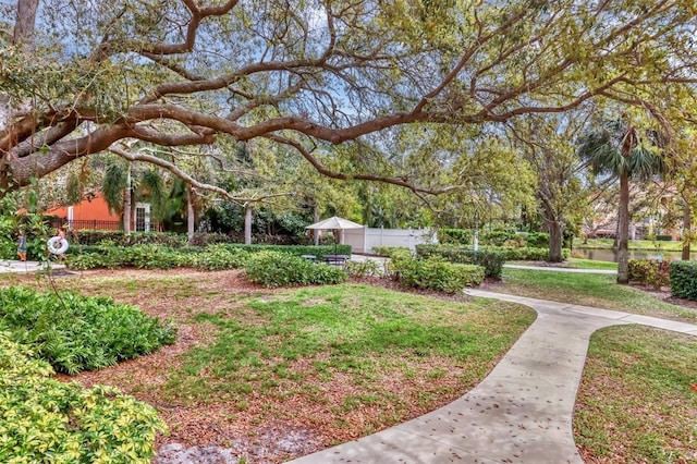 view of home's community with a lawn and fence