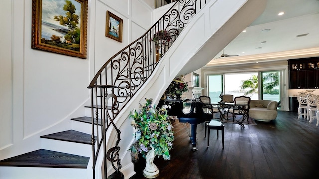 staircase featuring recessed lighting, wood-type flooring, and crown molding