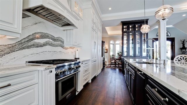 kitchen featuring premium range hood, a sink, ornamental molding, stainless steel range, and dark cabinets