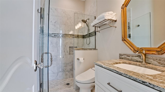 bathroom with vanity, toilet, and a stall shower