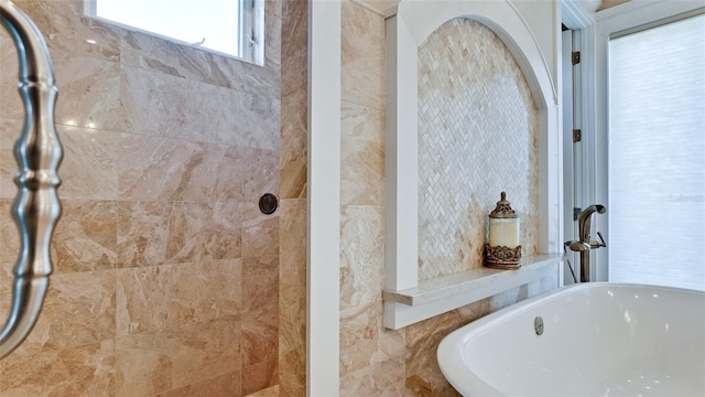 full bath featuring a freestanding tub and a tile shower