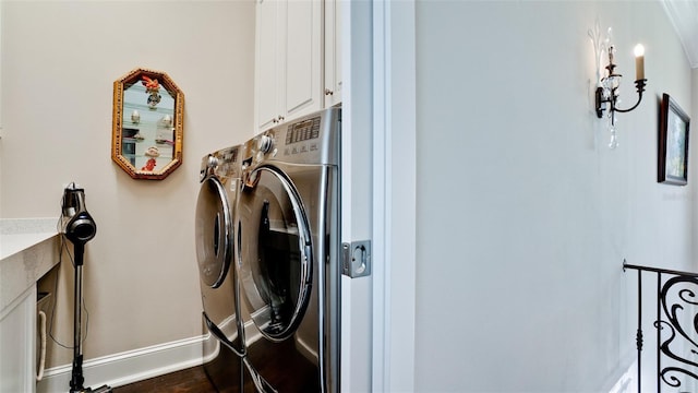 laundry room with baseboards, cabinet space, and washer and clothes dryer