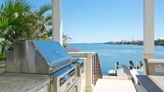 view of patio / terrace featuring area for grilling, a water view, and a grill