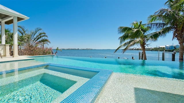 view of swimming pool featuring a water view and a pool with connected hot tub