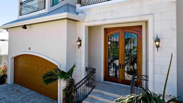 doorway to property with french doors, a balcony, concrete block siding, and stucco siding