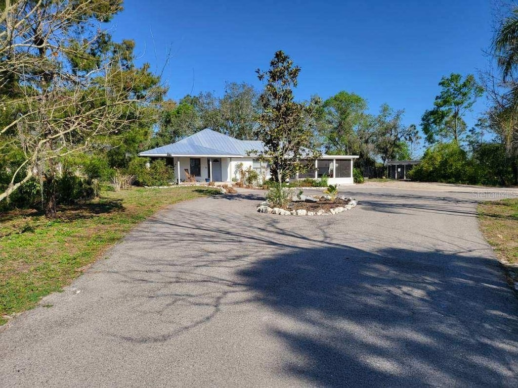 view of front of home featuring aphalt driveway and metal roof