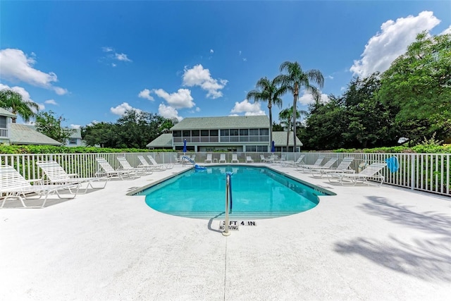 pool with a patio and fence