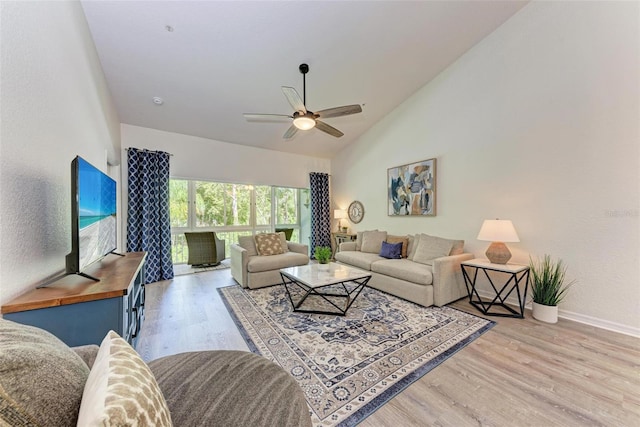 living area with high vaulted ceiling, baseboards, light wood-type flooring, and ceiling fan