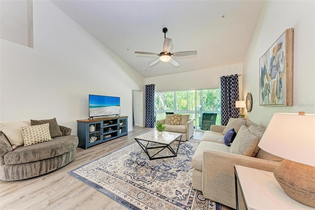 living room with a ceiling fan, lofted ceiling, and wood finished floors