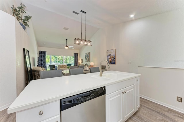 kitchen with white cabinetry, ceiling fan, a sink, stainless steel dishwasher, and open floor plan