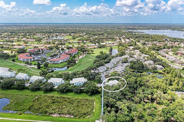 drone / aerial view featuring view of golf course, a water view, and a residential view