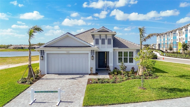 view of front facade featuring an attached garage, stucco siding, a front lawn, and decorative driveway