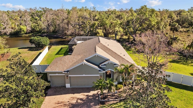 birds eye view of property with a view of trees and a water view