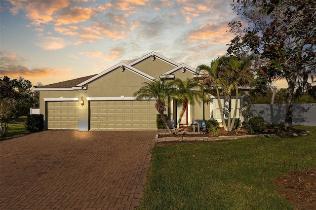 view of front of house featuring decorative driveway, a garage, and stucco siding