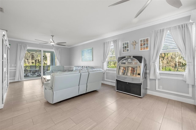 living area with visible vents, baseboards, crown molding, and a ceiling fan