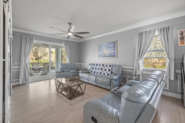 living area featuring a healthy amount of sunlight, a ceiling fan, and ornamental molding