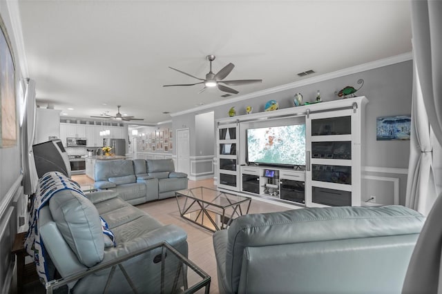 living area with light wood-type flooring, visible vents, a ceiling fan, and crown molding