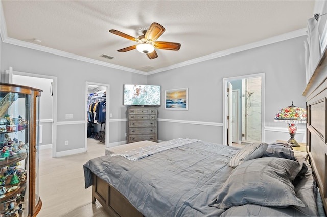 bedroom featuring visible vents, ornamental molding, a closet, light wood finished floors, and a spacious closet