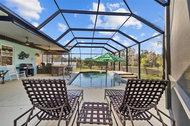 view of swimming pool with grilling area, a fenced in pool, ceiling fan, a patio area, and an outdoor kitchen