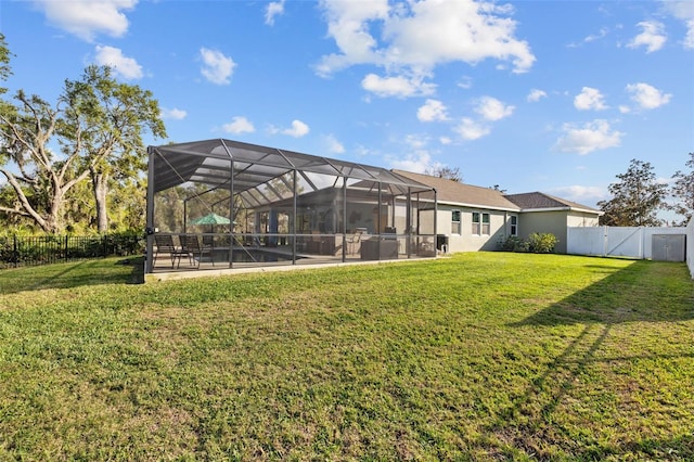 view of yard with glass enclosure, a patio area, a gate, and a fenced backyard