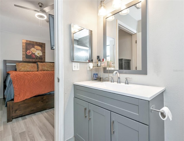 bathroom featuring ceiling fan, vanity, wood finished floors, and ensuite bathroom