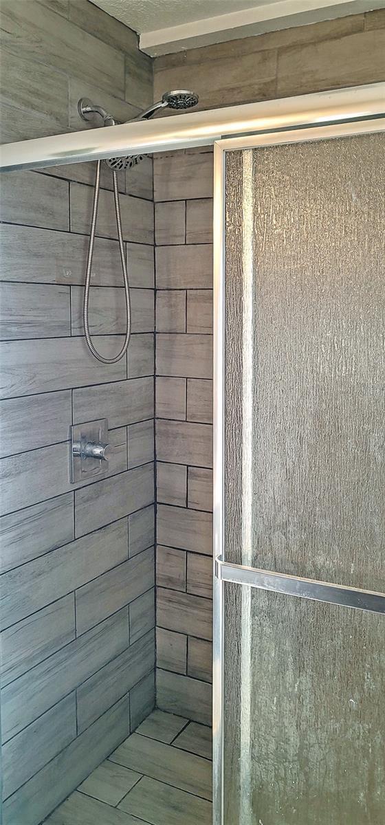 full bath with a tile shower