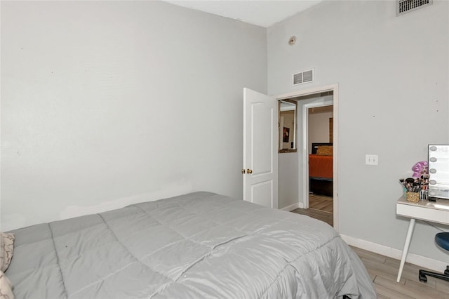 bedroom featuring visible vents, baseboards, and light wood-style floors