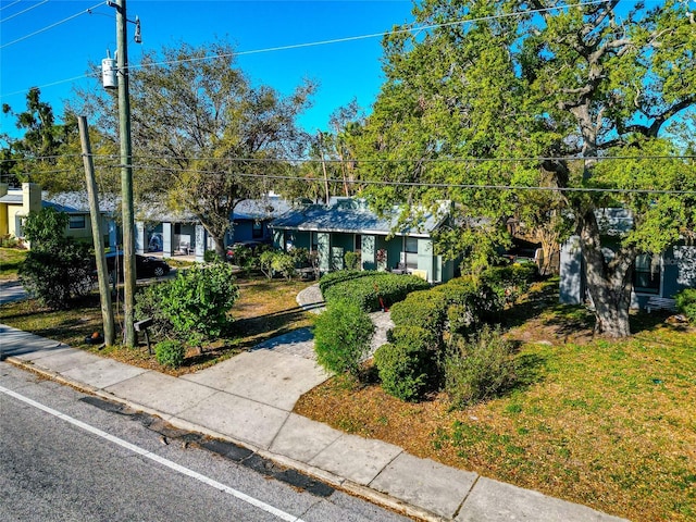 view of property hidden behind natural elements featuring a front yard