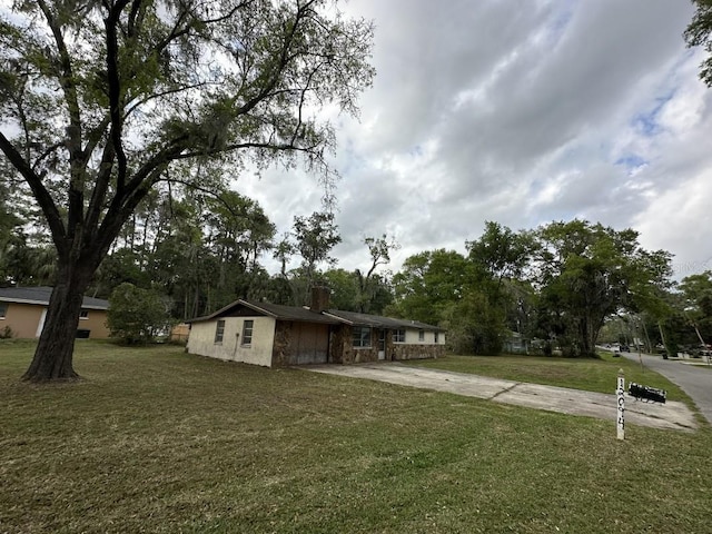 view of yard featuring an attached garage and driveway