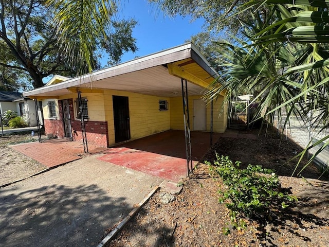 exterior space featuring a carport, driveway, and brick siding