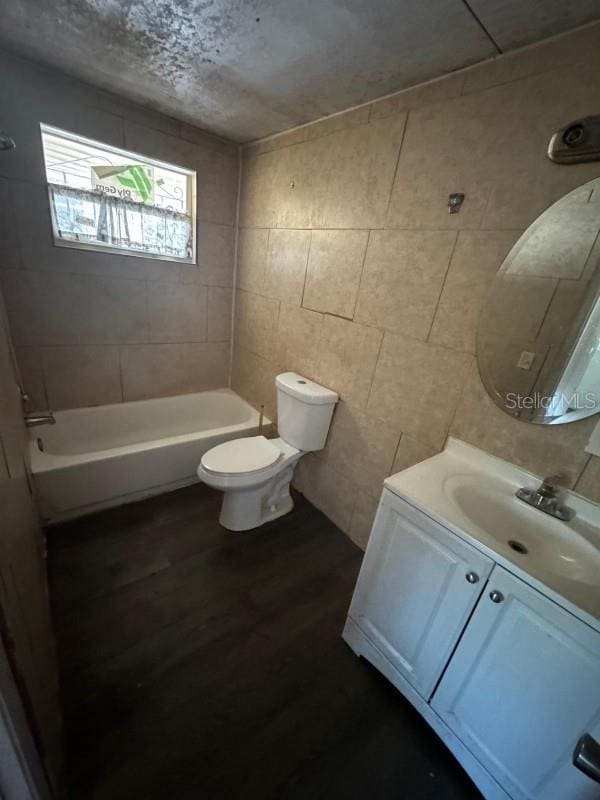 full bathroom with shower / bathing tub combination, toilet, wood finished floors, and vanity