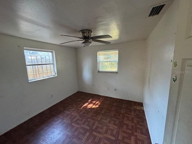 empty room with visible vents, a textured ceiling, and ceiling fan