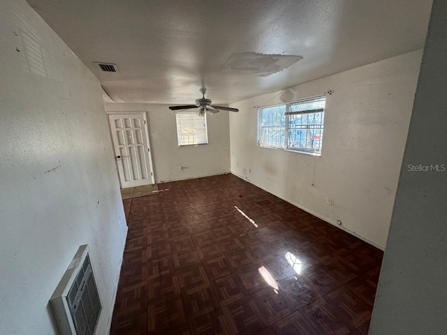 unfurnished room featuring visible vents, a textured ceiling, and ceiling fan