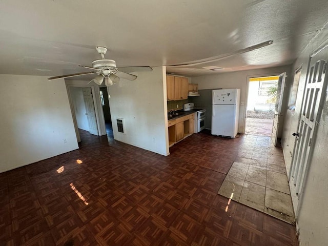 kitchen featuring visible vents, ceiling fan, light brown cabinetry, range with two ovens, and freestanding refrigerator