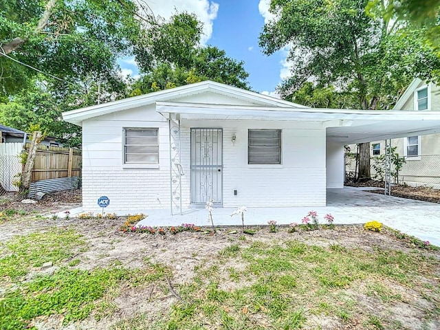 3512 N 10th St, Tampa, FL 33605 - bungalow with concrete driveway, fence, a carport, and brick siding