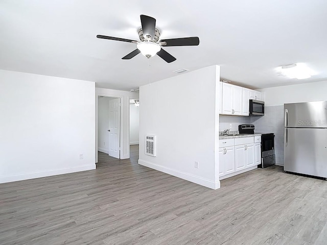 3512 N 10th St, Tampa, FL 33605 - unfurnished living room with light wood-type flooring, baseboards, visible vents, and ceiling fan