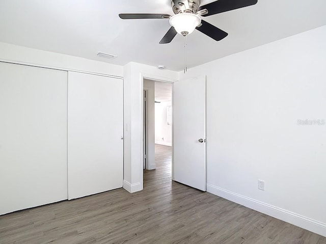 3512 N 10th St, Tampa, FL 33605 - unfurnished bedroom with wood finished floors, a closet, ceiling fan, baseboards, and visible vents