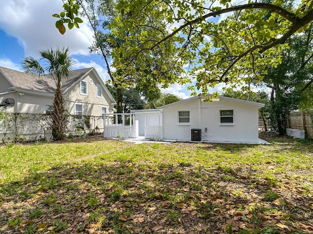 3512 N 10th St, Tampa, FL 33605 - rear view of house featuring stucco siding, fence, central AC, and a lawn