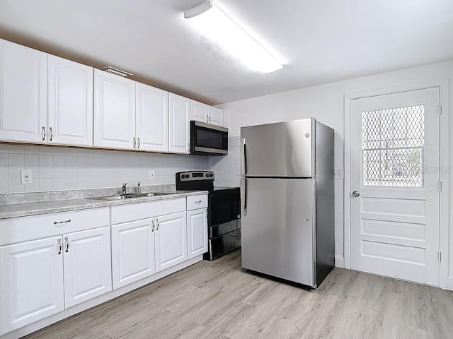 3512 N 10th St, Tampa, FL 33605 - kitchen with light countertops, light wood finished floors, appliances with stainless steel finishes, and a sink