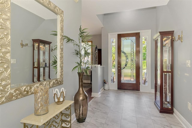 entrance foyer featuring baseboards and marble finish floor