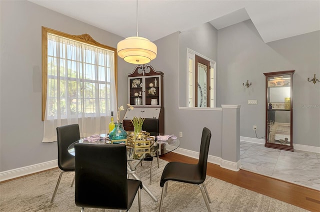 dining space featuring baseboards and wood finished floors