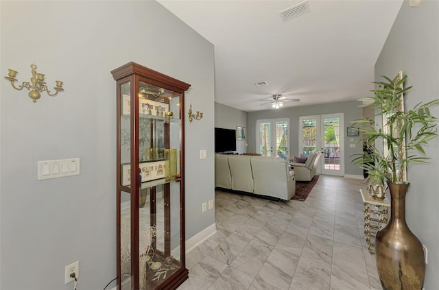 living room featuring a ceiling fan, visible vents, marble finish floor, and baseboards