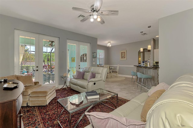 living area featuring french doors, baseboards, and a ceiling fan