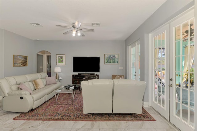 living room with arched walkways, marble finish floor, french doors, and a ceiling fan